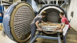 At GE Aviation&apos;s ceramics lab in Newark, Del., workers load molded CMC forms into an autoclave, to set the shape prior to thermal processing, to remove the polymer and leave &ldquo;a hollow shell&rdquo; of ceramic-coated carbon fibers in a solid, lightweight form.