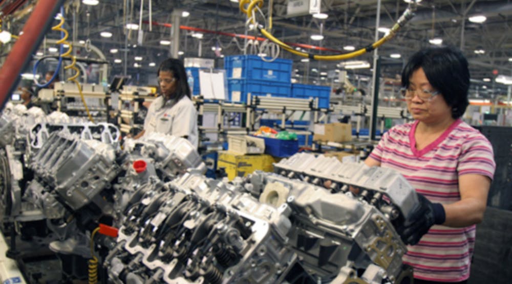 GM workers install lower head covers on Duramax diesel engines at the DMAX Ltd. plant in Dayton, Ohio.