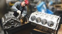Dart Machinery technician Bob Dimitrijevich installs Darton iron sleeves in cast aluminum block, as a billet aluminum racing block awaits installation. Aluminum block bores are honed for size and geometry before liner installation.