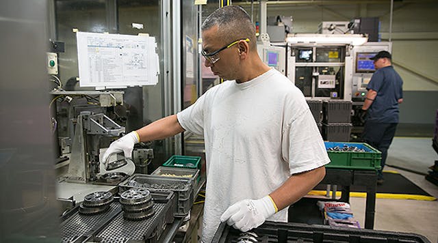 A GM employee assembles cam phasers at the General Motors Components Holdings, LLC plant in Wyoming, Mich.