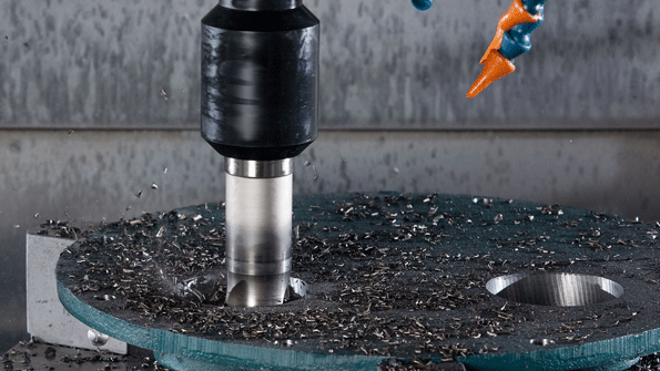 A closeup view of the holemaking process shows the Ingersoll HiFeed Deka face mill producing chips partway through a complete hole The tool withstands the lateral and impact forces associated with corkscrew milling the developer noted and because it has twice the diameter of the previous solidcarbide end mill it is less susceptible to deflection and it leaves no slug