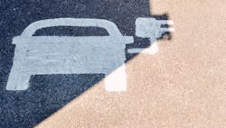 A painted road sign indicates an electric-vehicle recharging parking point. A painted road sign indicates an electric-vehicle recharging parking point.