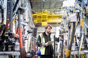 Cust Engineer Inspecting Press Machinery In Car Factory