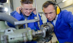 Apprentice with instructor protecting ears from noisy CNS machine. Apprentice with instructor protecting ears from noisy CNS machine.