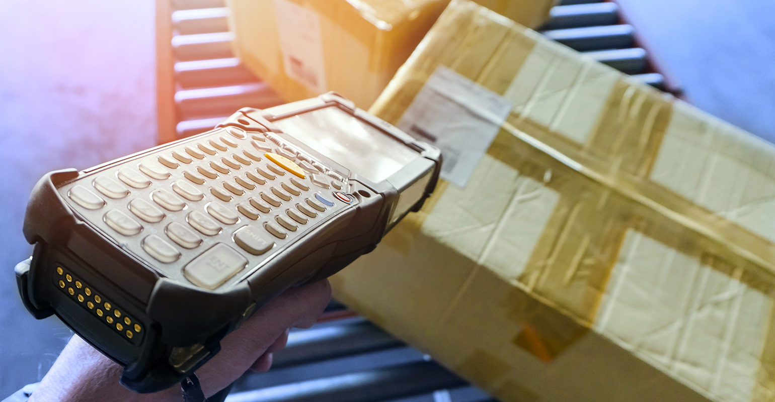 Worker scanning barcode on shipment boxes, manufacturing cargo warehouse.