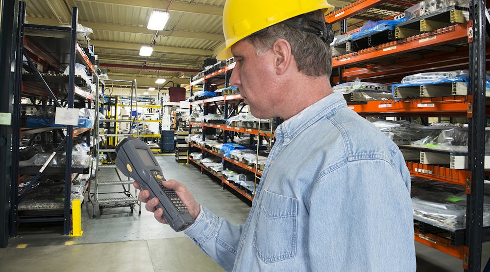 A worker is using a handheld scanner for inventory management control in a manufacturing warehouse operation.