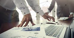 Business documents on office table with smart phone and digital tablet and stylus, and two colleagues discussing data in the background. Business documents on office table with smart phone and digital tablet and stylus, and two colleagues discussing data in the background.
