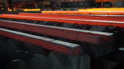 Hot steel billets, cooling on a walking-bed runout table after continuous casting.