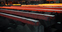 Hot steel billets, cooling on a walking-bed runout table after continuous casting. Hot steel billets, cooling on a walking-bed runout table after continuous casting.