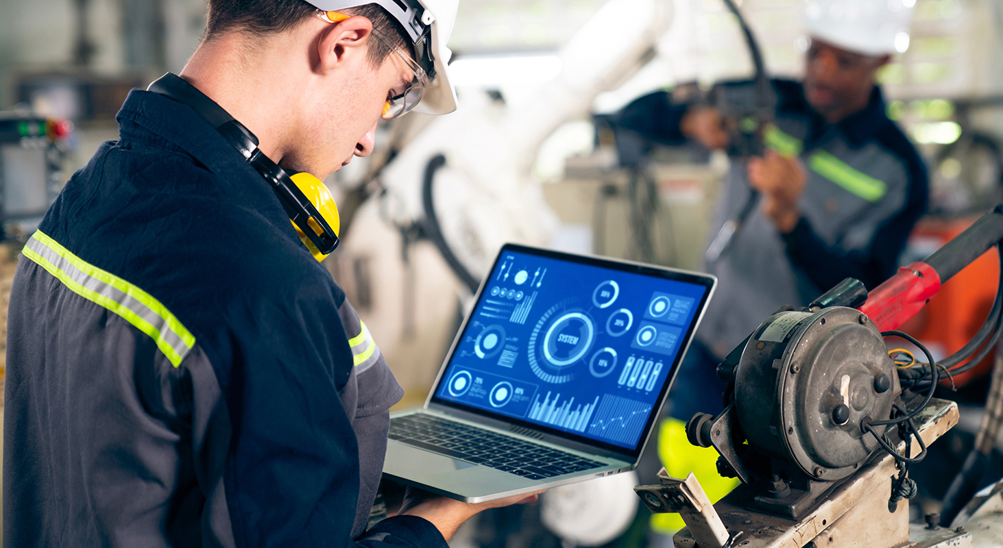 Factory worker working with adept robotic arm.