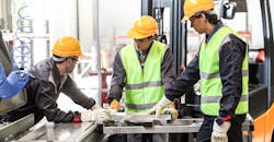 CNC machine shop workers in conversation. CNC machine shop workers in conversation.
