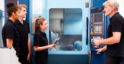 Apprentices working with engineer on a CNC machine. Apprentices working with engineer on a CNC machine.