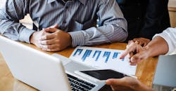 A business team evaluates project costs. A business team evaluates project costs.