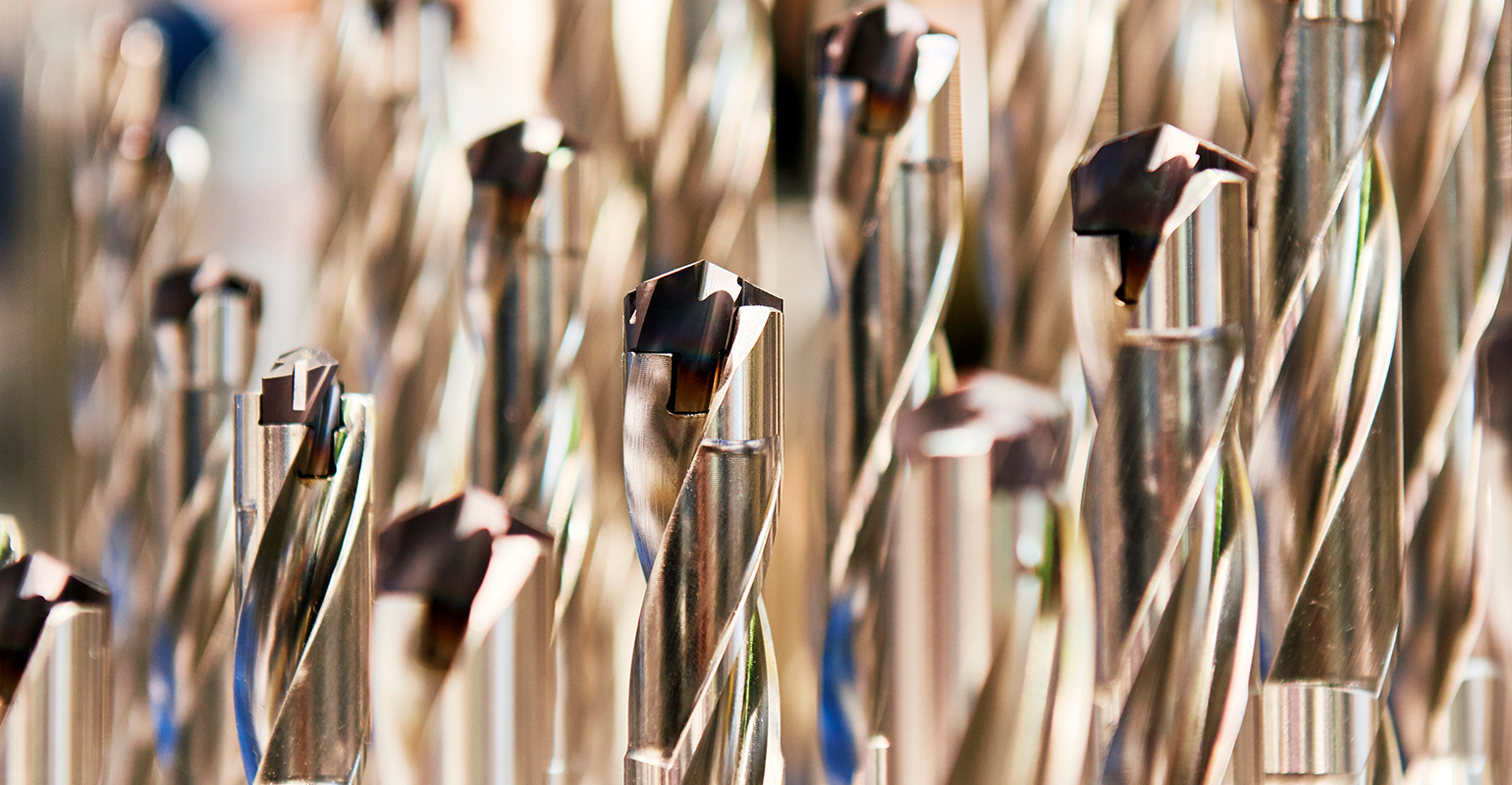 Finished metal drill tool set with protective coating and carbide insert.