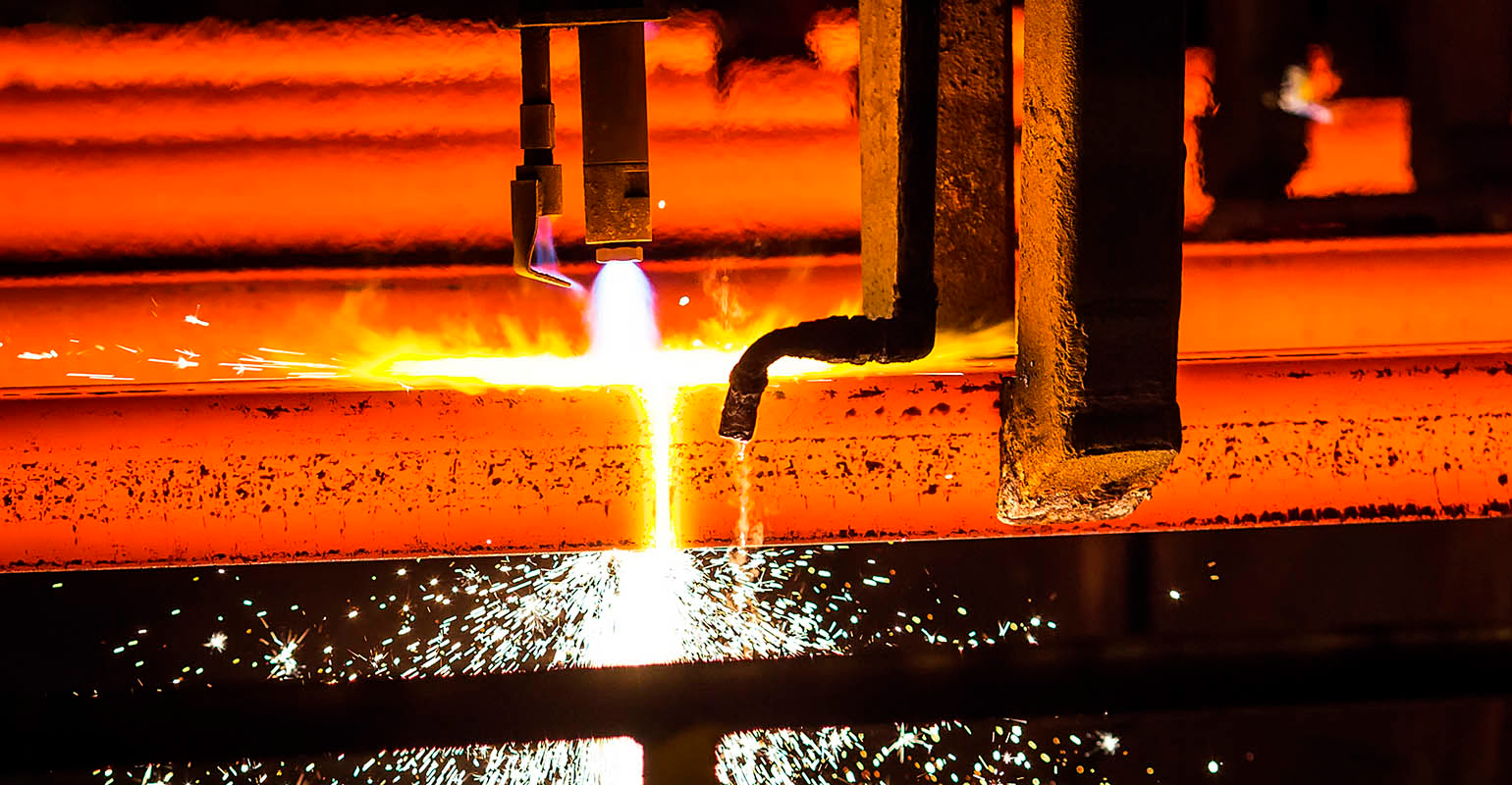 Oxy-torch cutting steel billets.