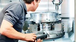 Worker operating CNC milling machine. Worker operating CNC milling machine.