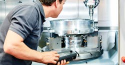 Worker operating CNC milling machine. Worker operating CNC milling machine.