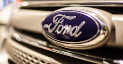 Ford blue oval logo on vehicle grille.