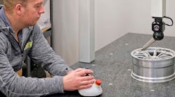 Ray Harris inspecting a scaled-down race car wheel for wind tunnel testing. Ray Harris inspecting a scaled-down race car wheel for wind tunnel testing.