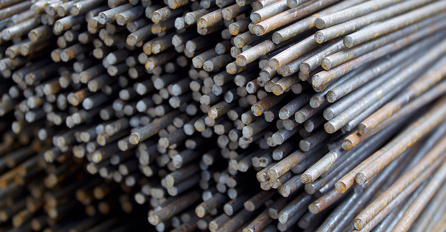 Stacked rebar, stored in a warehouse.
