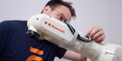 A technician manipulates a Kawasaki robot arm. A technician manipulates a Kawasaki robot arm.