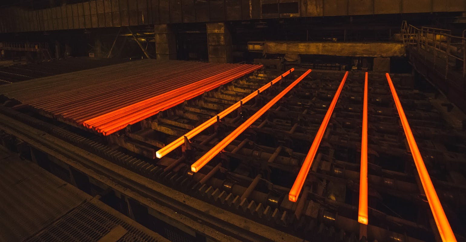 Hot steel billets cooling on a runout table.