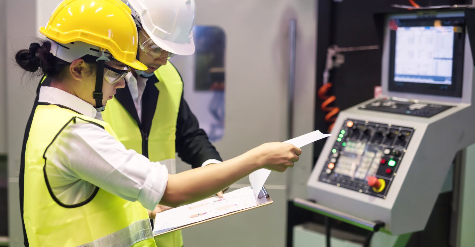 Plant inspector checks audit report.