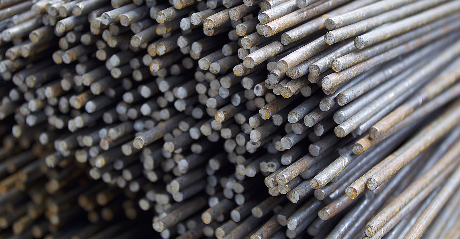 Stacked rebar, stored in a warehouse.