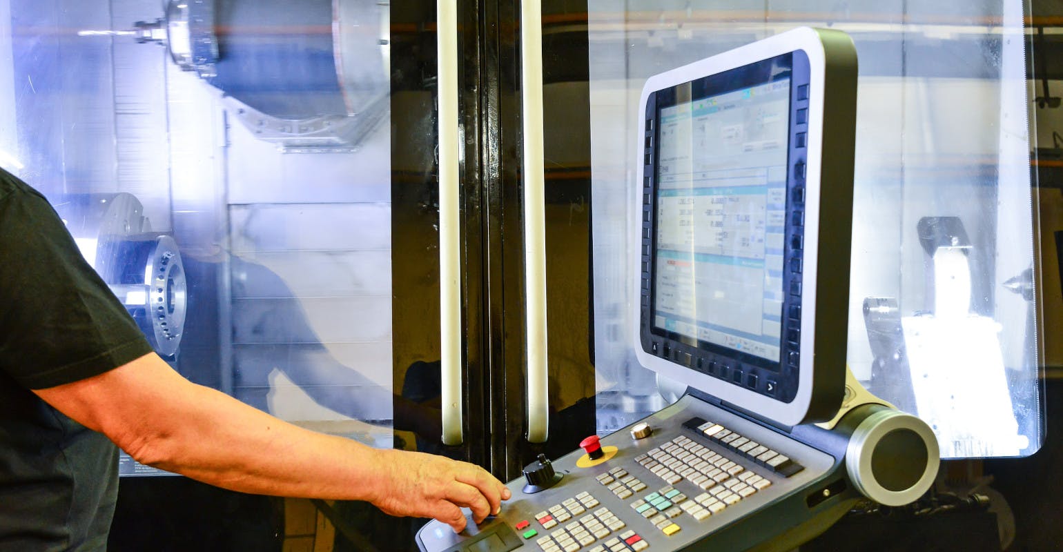 Operator at the control panel of a high-precision CNC machining center.