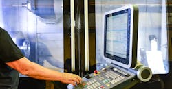 Operator at the control panel of a high-precision CNC machining center. Operator at the control panel of a high-precision CNC machining center.