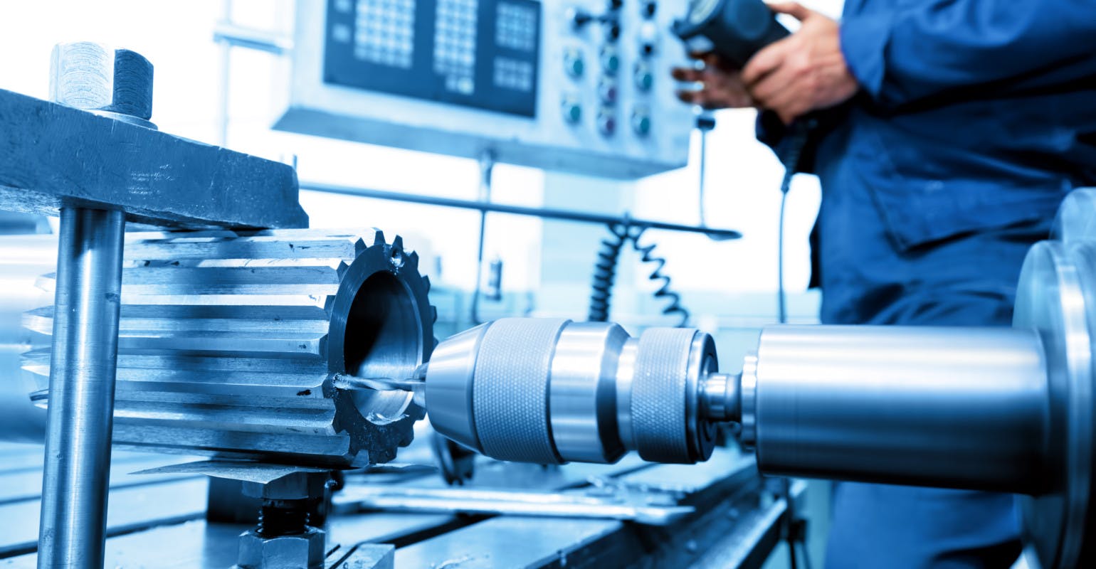 Man operating CNC drilling and boring machine.