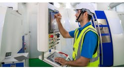 CNC operator recording data at a milling machine. CNC operator recording data at a milling machine.
