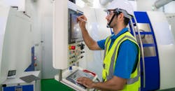 CNC operator recording data at a milling machine. CNC operator recording data at a milling machine.