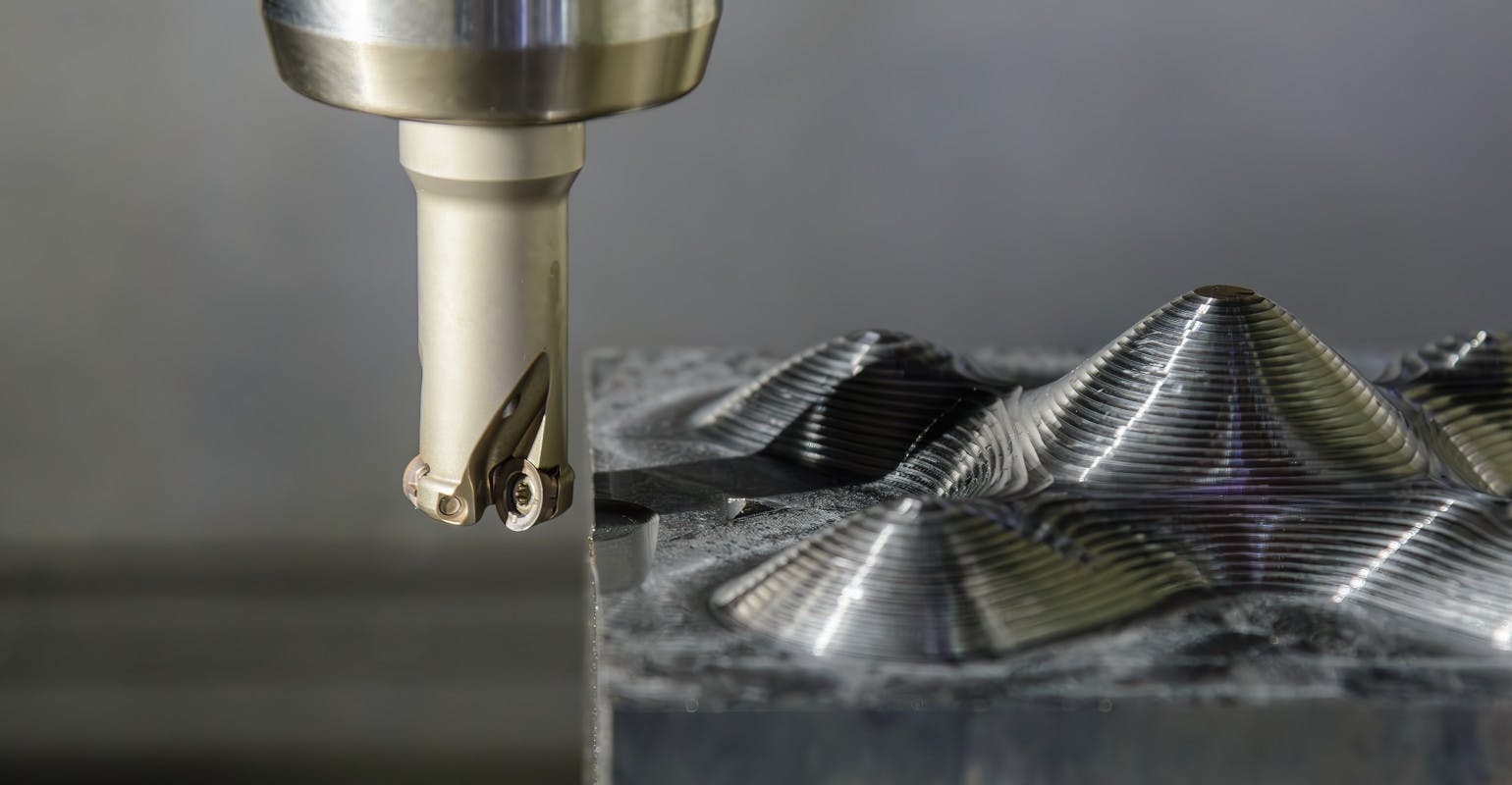 CNC milling machine rough-cutting an injection mold.