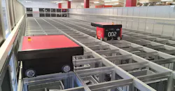 The AutoStore system involves compact robots navigating tracks above a high-density grid of storage bins.