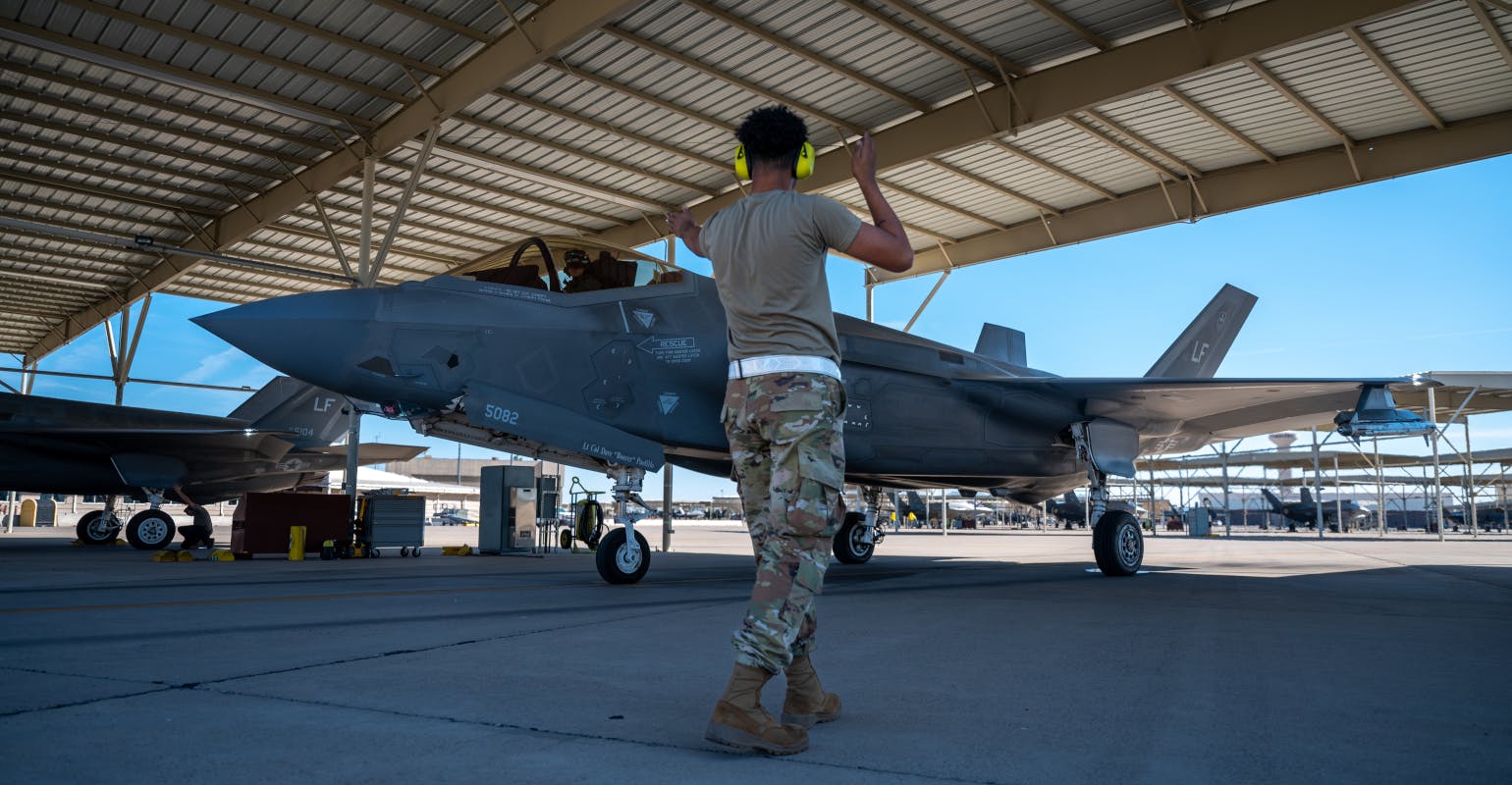 USAF Aircraft Maintenance Unit crew chief, directs an F-35A Lightning II for takeoff.