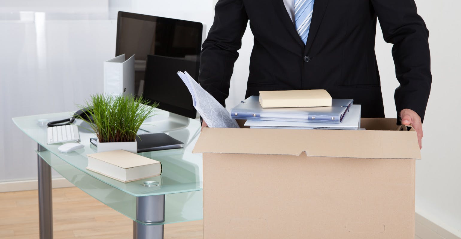 Salaried worker packs up his desk.