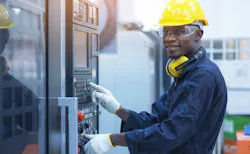 Man working at CNC machine. Man working at CNC machine.