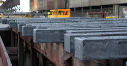 Hot steel billets on cooling table.