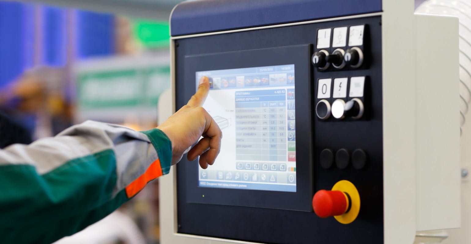 Operator prepares CNC machine for new task.