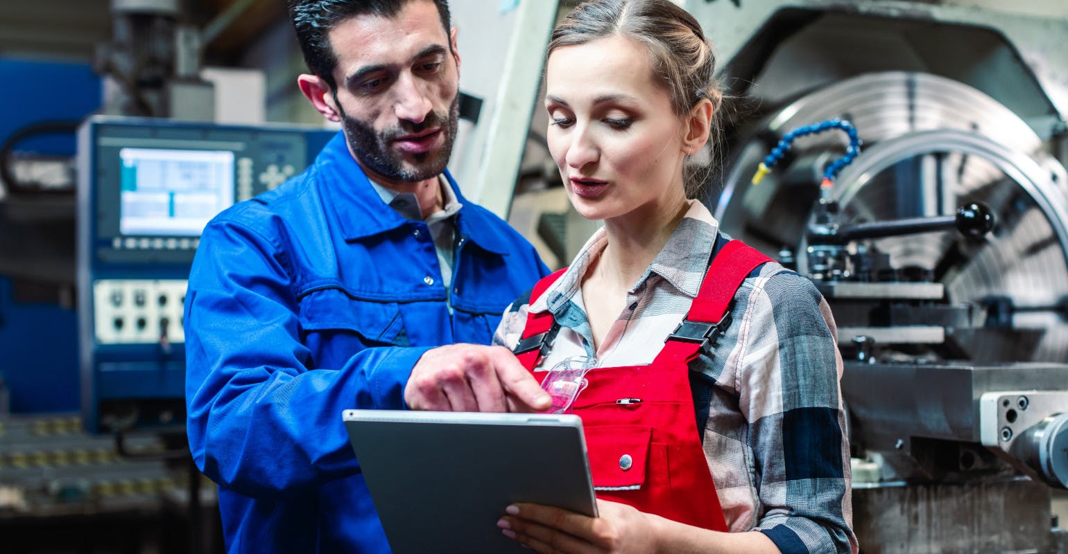 Manufacturing co-workers in discussion, with tablet.