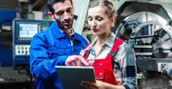 Manufacturing co-workers in discussion, with tablet.
