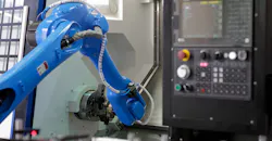 Robot loading parts into CNC lathe machine.