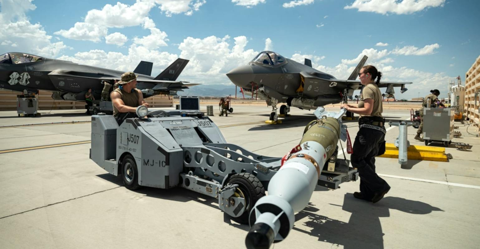 U.S. Air Force Staff Sgt. Jessika Steele, right, and Senior Airman Immanuel Bailey, left, transport a GBU-12 Paveway II bomb to load on to an F-35 Lightning II at Nellis Air Force Base, Nevada, Aug. 11, 2023.