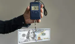 Weighing operating costs, dollar bill on electronic scales.